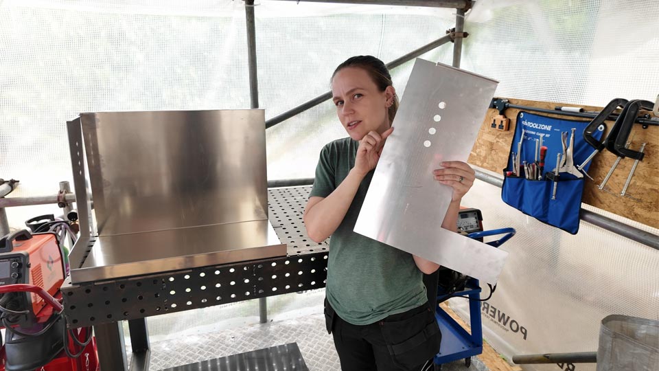 Hayley holding some laser cut aluminium parts ready for welding