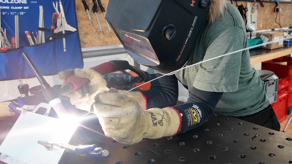 A woman using an AC TIG welder