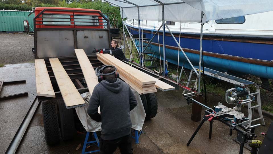 Hayley & Pete fitting wooden board to their truck's flatbed