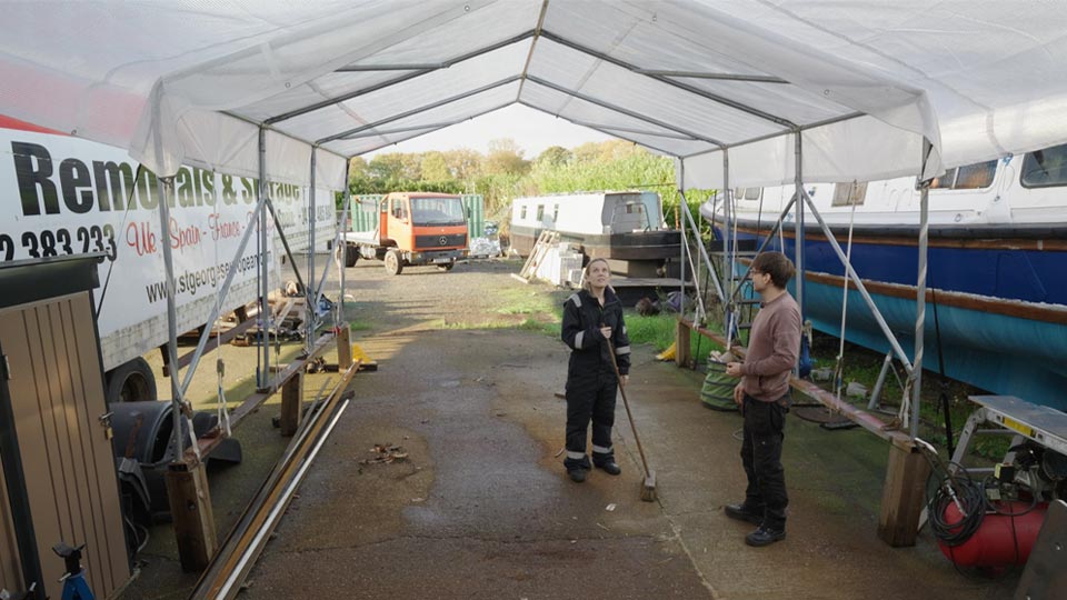 Pete and Hayley under their makeshift marquee with Moose in the sunlit distance