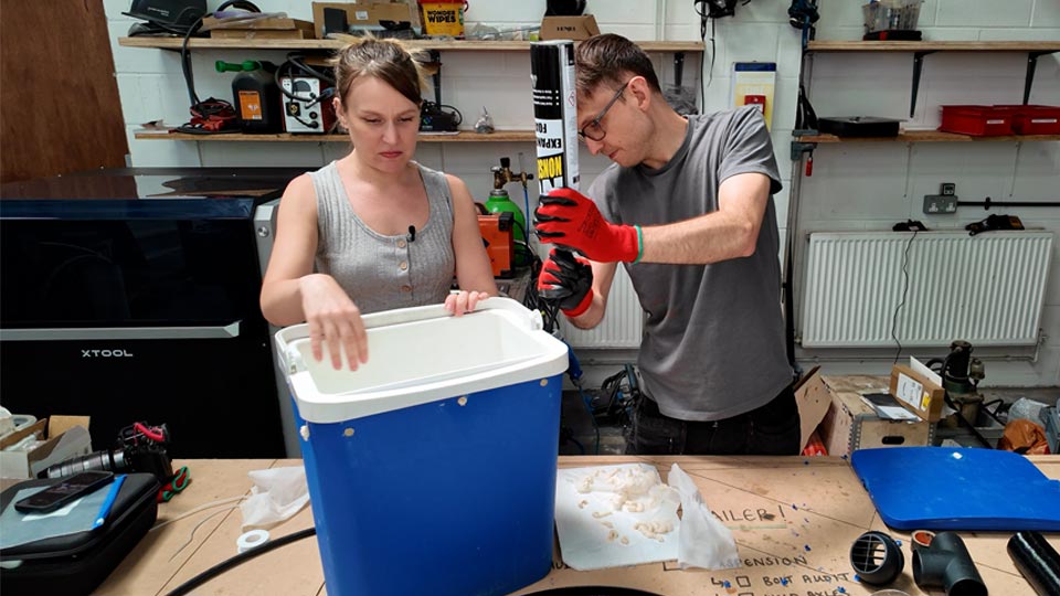Expanding foam being injected into the cool box wall through a small hole